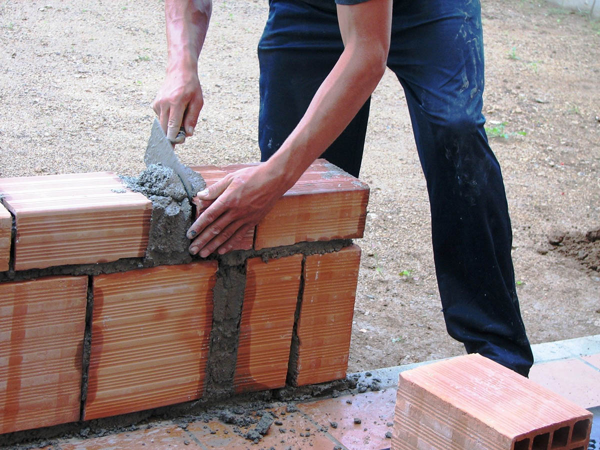 Trabajador construyendo una pared de ladrillos Trabajador construyendo una pared de ladrillos